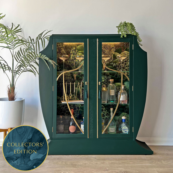 Luxurious green Art Deco cocktail cabinet styled with spirits and glassware, featuring gold accents and Cole & Son Forest interior.