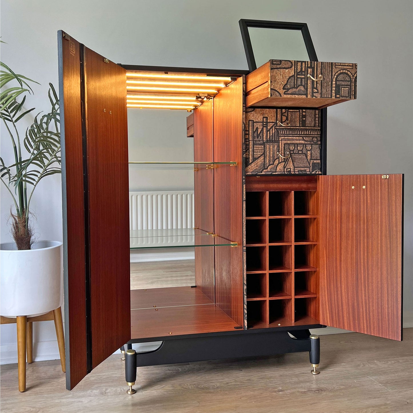 G Plan Librenza drinks cabinet interior with full-length mirror, LED-lit glass shelves, and dedicated wine storage, designed for stylish barware organisation.