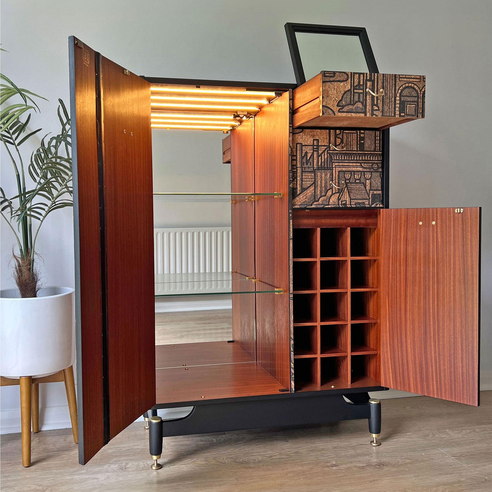 G Plan Librenza drinks cabinet interior with full-length mirror, LED-lit glass shelves, and dedicated wine storage, designed for stylish barware organisation.
