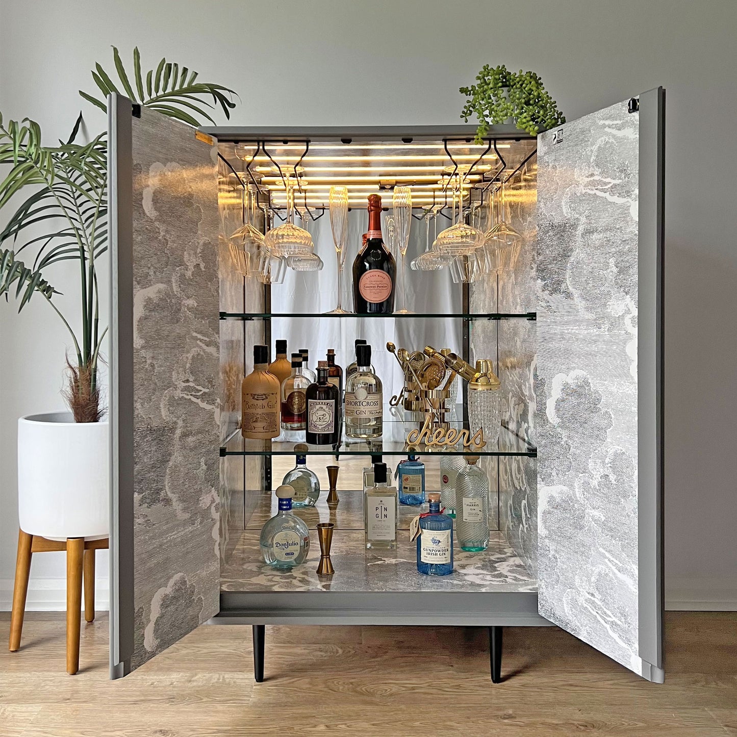 Luxury John & Sylvia Reid Stag C Range drinks cabinet with open doors, styled with glassware and fine spirits. Spacious shelves accommodate standard-sized wine bottles, while integrated glass racks hold stemware elegantly.