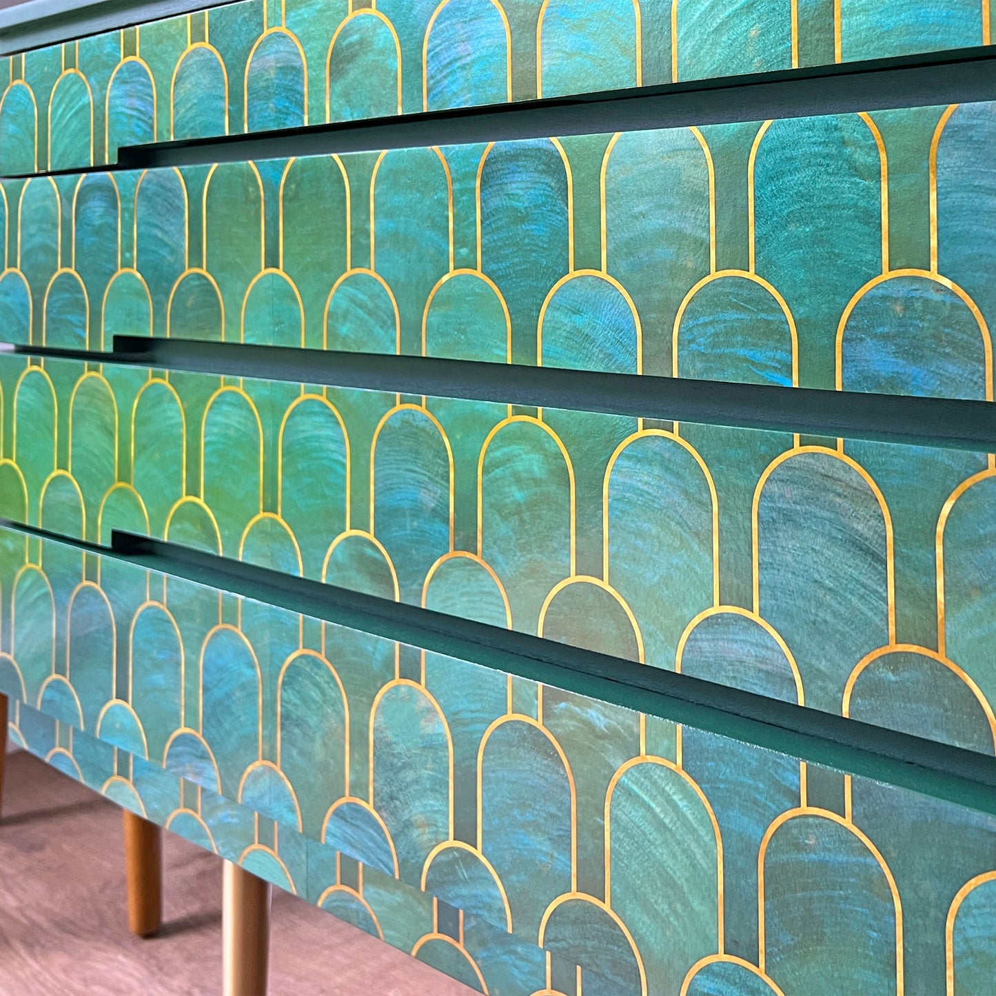 Close-up of iridescent shell-like decoupage on vintage sideboard, designed by acclaimed British designer Bethan Gray, reflecting a luxurious sheen.