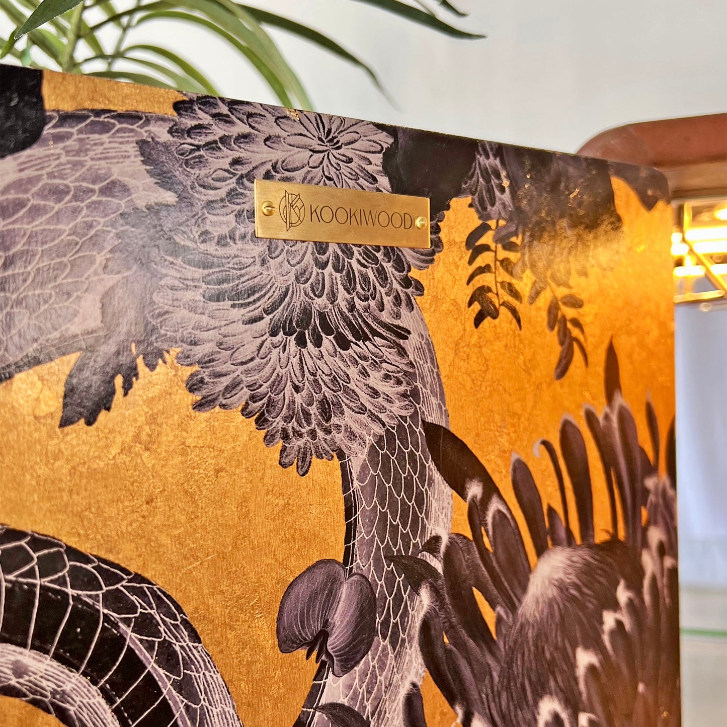 Brass Kookiwood brand plaque affixed to Divine Savages Forbidden Bloom wallpaper in real gold leaf inside a luxury Art Deco drinks cabinet.