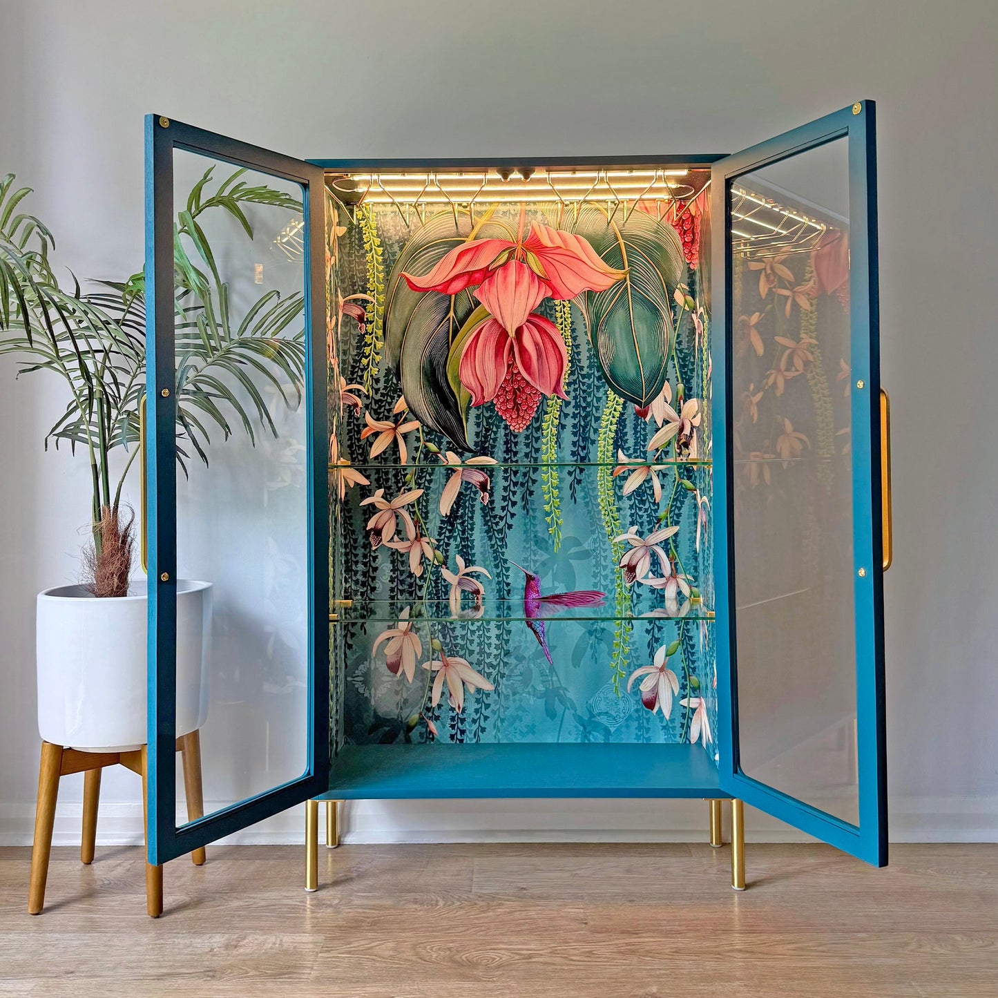 Open view of a restored G Plan cabinet with interior floral mural, integrated glass racks, and LED lighting.