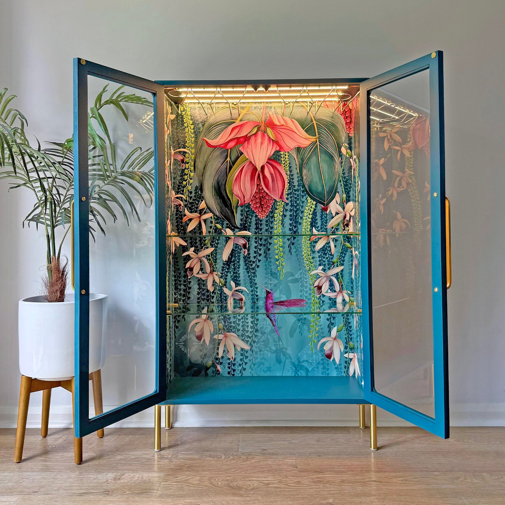 Open view of a restored G Plan cabinet with interior floral mural, integrated glass racks, and LED lighting.