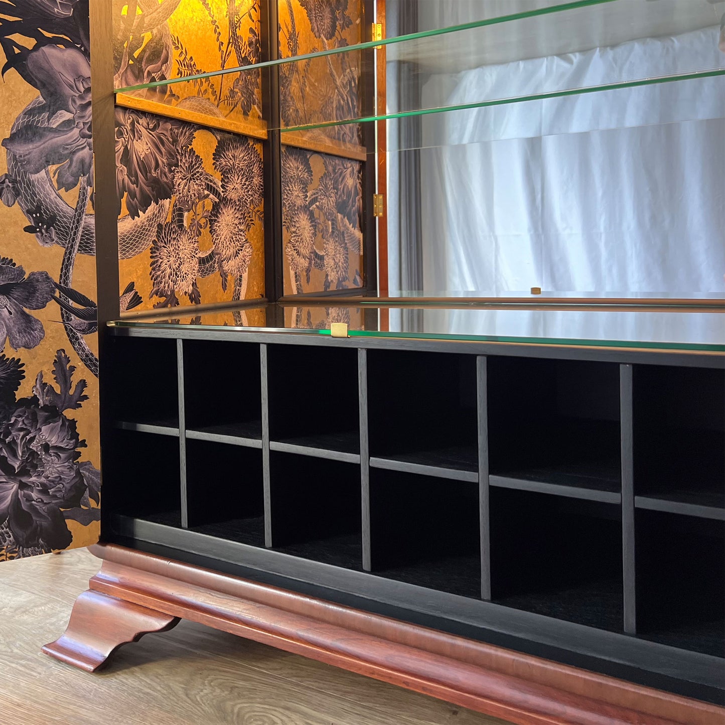 Close-up of the wine bottle storage and mirrored interior, set against Divine Savages Forbidden Bloom wallpaper hand-gilded in real gold leaf.