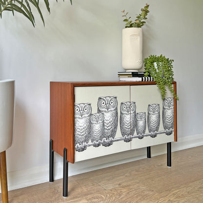 Side profile of G Plan cabinet, featuring a unique Fornasetti owl print, sleek matte black legs, and a clean, handle-less door design.