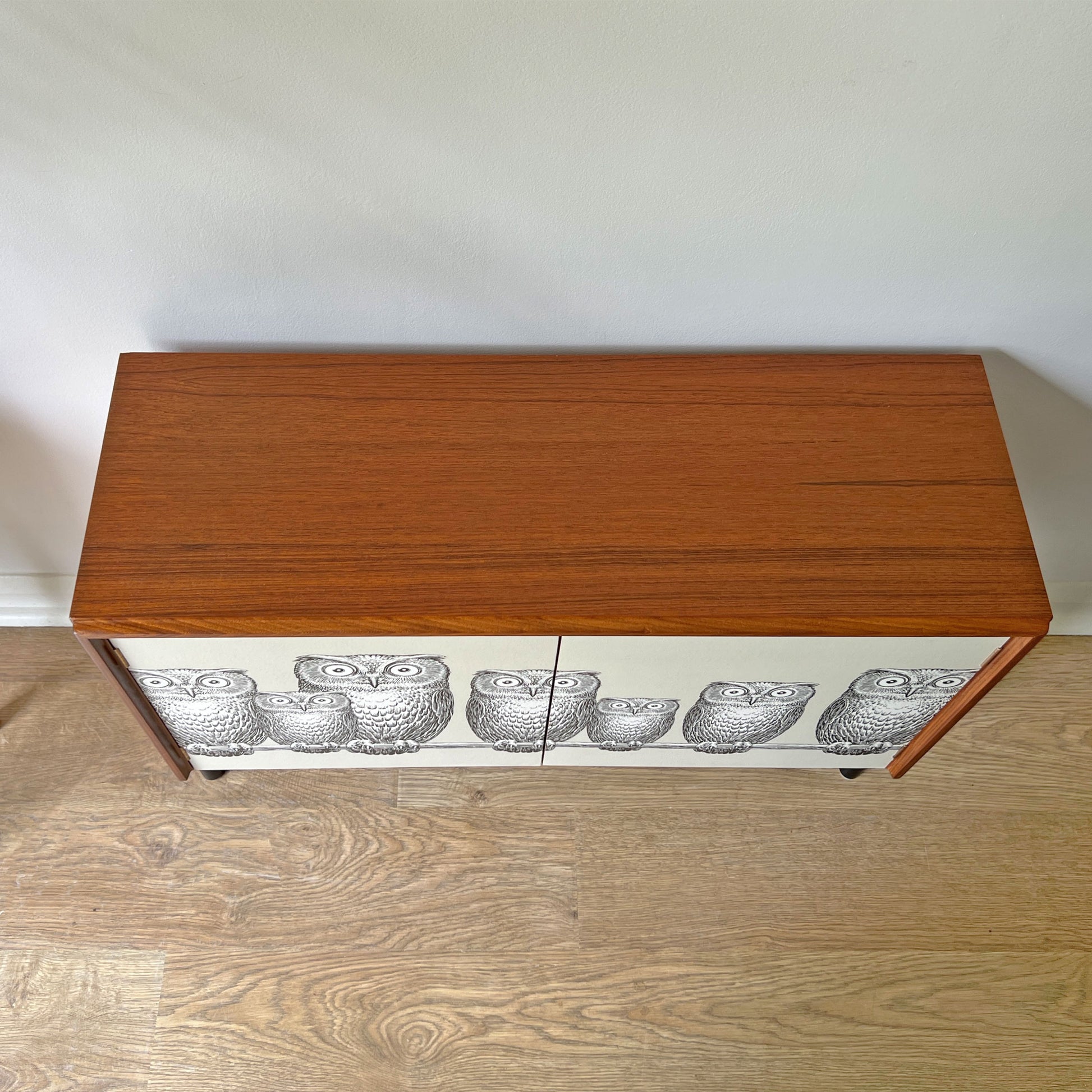 Top view of G Plan cabinet with smooth refinished surface, complementing the striking Fornasetti ‘Nottambule’ owl print.
