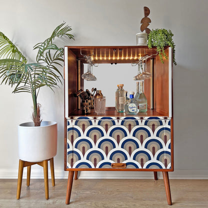 Refinished G Plan drinks cabinet with mirrored back panel, brass glass racks, and mains-powered LED lighting, styled with glassware and bottles.