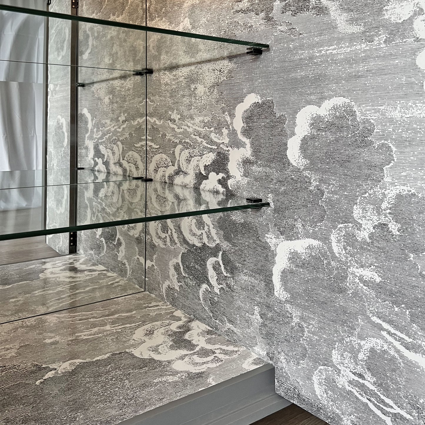 Atmospheric Fornasetti 'Nuvolette' cloudscape design inside drinks cabinet, creating an illusion of an endless sky.