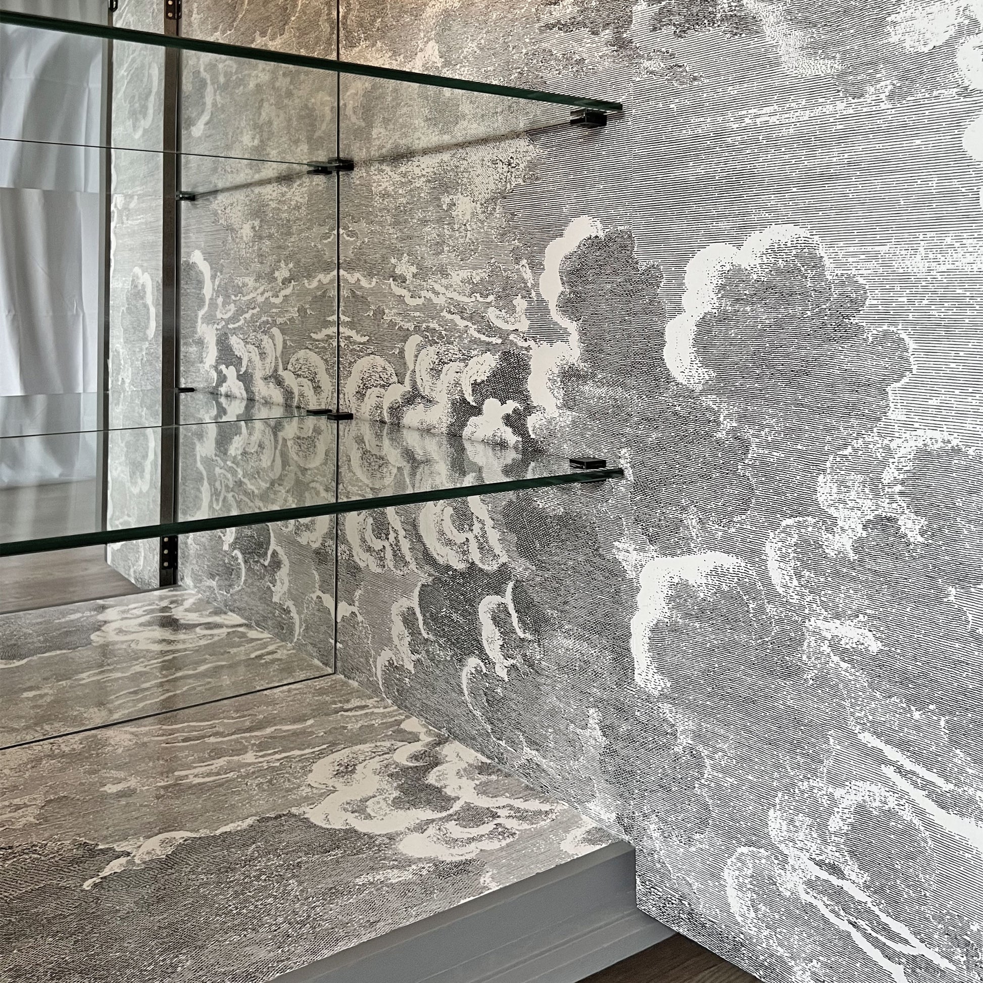 Atmospheric Fornasetti 'Nuvolette' cloudscape design inside drinks cabinet, creating an illusion of an endless sky.