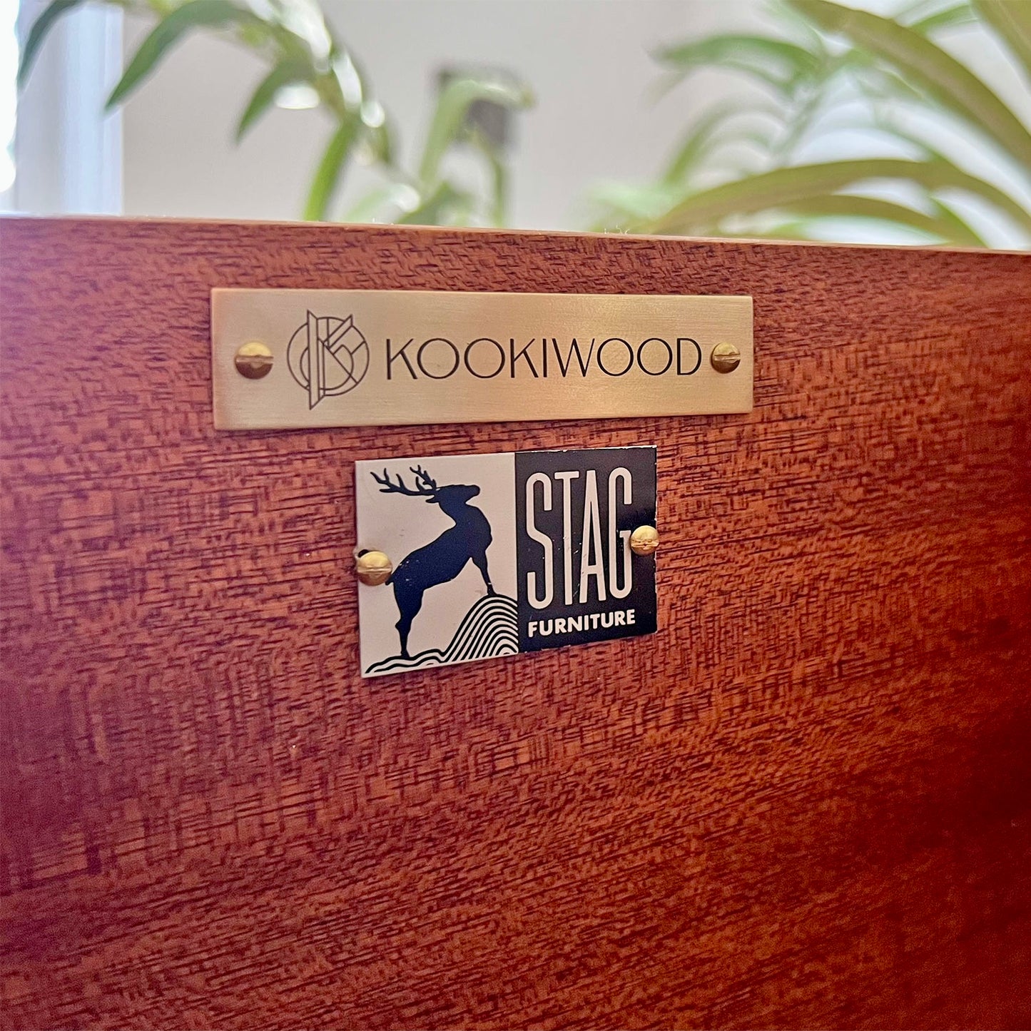 Close-up of Kookiwood brass branding tag affixed to the Stag C Range tallboy, signifying bespoke craftsmanship and exclusivity.
