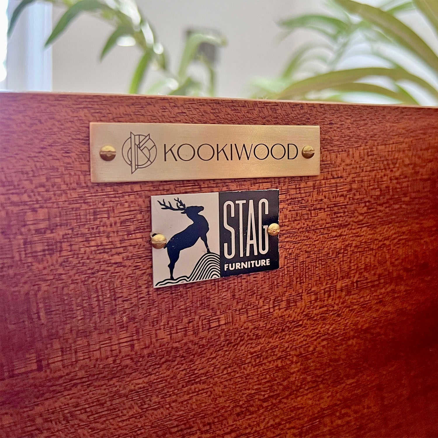 Close-up of Kookiwood brass branding tag affixed to the Stag C Range tallboy, signifying bespoke craftsmanship and exclusivity.